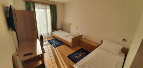 a small room with two beds and a window at Gasthof Kasperle in Spittal an der Drau