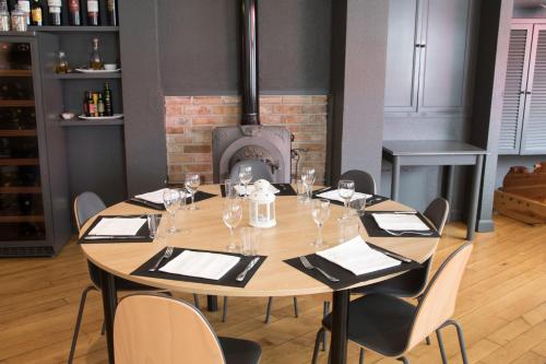a wooden table with chairs around it with a fireplace at Hotel Casa Jacinto Pamplona in Burlada