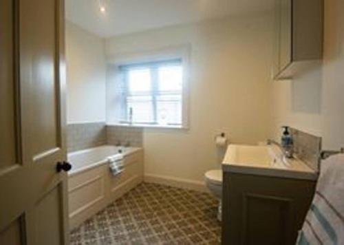 a bathroom with a sink and a toilet and a window at Church Lane Holiday Home, Warrenpoint in Warrenpoint