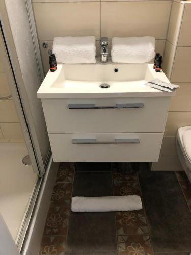 ein Badezimmer mit einem weißen Waschbecken und einem WC in der Unterkunft Dolcevita in Bad Bertrich