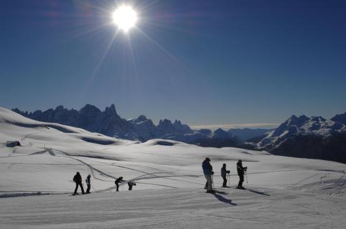 a group of people skiing on a snow covered mountain at Cimon Dolomites Hotel in Predazzo