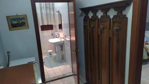 baño con lavabo y puerta de madera con espejo en Casa fiordaliso, en Bonea