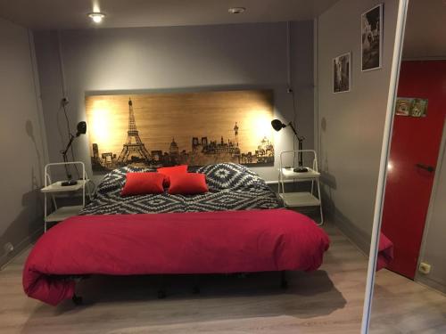 a bedroom with a large bed with red pillows at au parc Montsouris in Paris