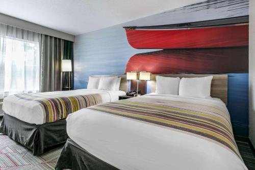 a hotel room with two beds and a large window at Clarion Pointe Columbus-Bradley Park in Columbus