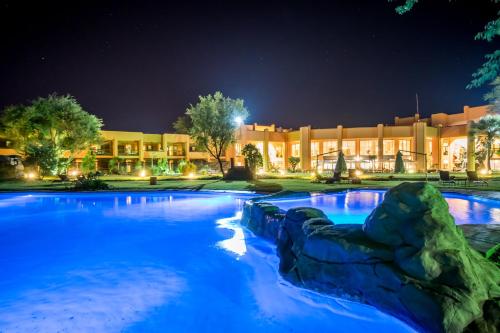 uma grande piscina com água azul à noite em Windhoek Country Club Resort em Windhoek