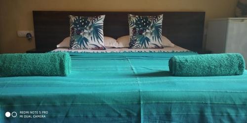 
a bed that has a blue blanket on top of it at Hotel Bonanza in Baga
