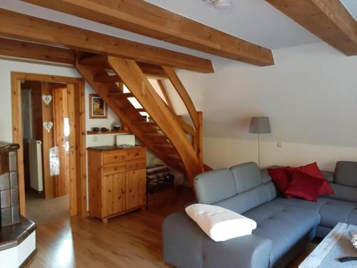 a living room with a blue couch and wooden beams at Ferienhaus Kerstin in Lindow