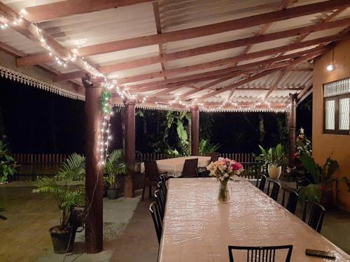 a table with a vase of flowers and lights at Nature's Hideout Holiday Home in Mirigama