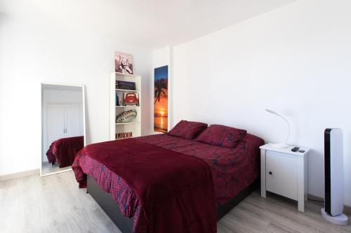 una camera con un letto con una coperta rossa di Atlantic Sunrise a Santa Cruz de Tenerife