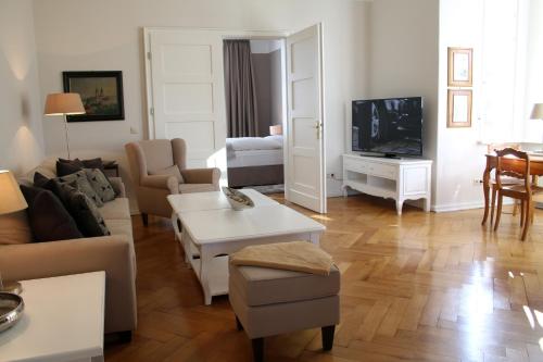 a living room with a couch and a tv at Romantik Hotel am Brühl in Quedlinburg