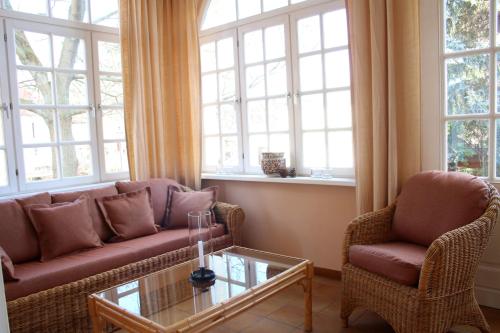 a living room with two couches and a table and windows at Romantik Hotel am Brühl in Quedlinburg