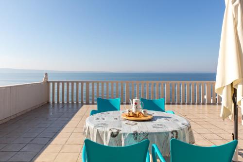 a table and chairs on a balcony with the ocean at Apartments Antonio - Podstrana, Split in Podstrana