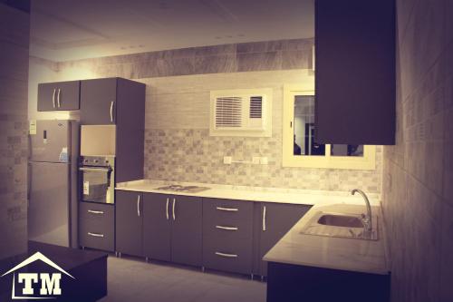 a kitchen with purple cabinets and a sink and a refrigerator at شقق الزوايا الهادئه للشقق المخدومة - اقتصادي - Alzwaya Alahadea Apartments in Jeddah