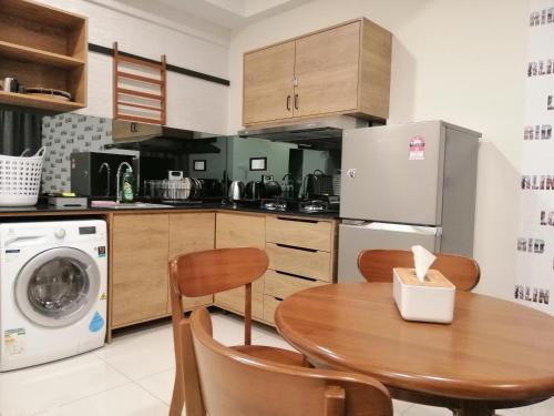 cocina con mesa, lavadora y secadora en Timurbay Seafront Residence Apartment 2 Room with garden view by imbnb, en Kampung Sungai Karang