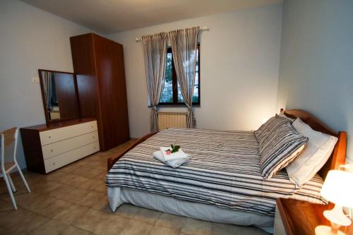 a bedroom with a bed and a dresser and a window at AceroRosso B&B in Salerno