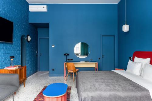 a bedroom with blue walls and a bed and a desk at P17 Hotel in Moscow