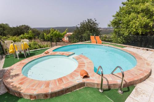 a large swimming pool with a wooden deck around it at Casa Adega - Quinta Amoreira in Faro