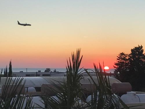 an airplane is flying in the sky at sunset at Aphrodite Sands Resort - The Penthouse in Mandria