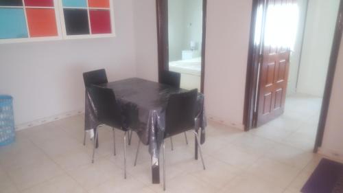 a black table with black chairs in a room at Kololi 2 Bed room Apartment in Kololi