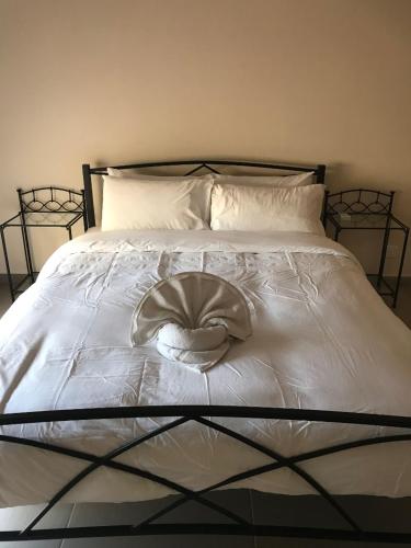 a white bed with a hat on top of it at Aphrodite Sands Resort - The Penthouse in Mandria