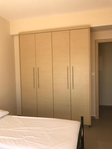 a bedroom with a bed and some closets at Aphrodite Sands Resort - The Penthouse in Mandria