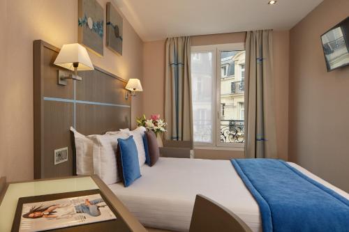 ein Hotelzimmer mit einem großen Bett und einem Fenster in der Unterkunft Alizé Grenelle Tour Eiffel in Paris
