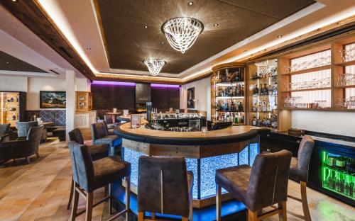 
a dining room with a bar and a large window at Wellnesshotel Cervosa in Serfaus
