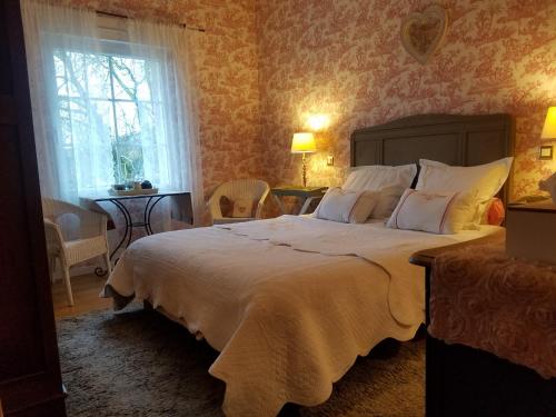 a bedroom with a large bed and a window at Chambres d'Hôtes Le Clos Du Verger in Cattenom