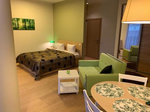 um quarto de hotel com uma cama, uma mesa e cadeiras em Brolių studija em Druskininkai