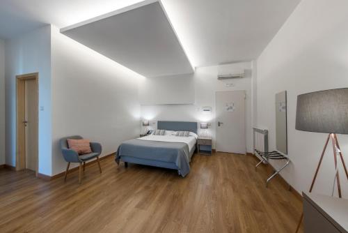 um quarto com uma cama e uma cadeira em Villa Albina em Nápoles