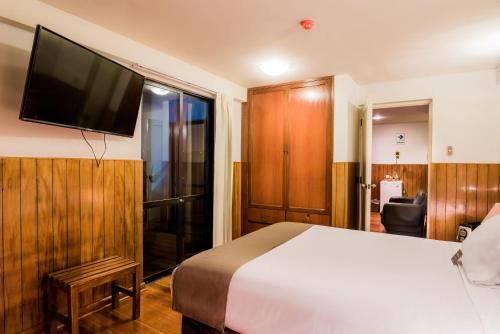 a bedroom with a bed and a television on a wall at DM Hoteles Arequipa in Arequipa