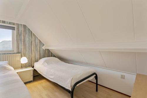 een witte kamer met een bed en een raam bij Noordzeepark Zuiderdiep 37 - Ouddorp near the beach - not for companies in Ouddorp