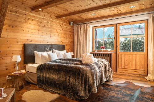 a bedroom with a bed and a wooden wall at Chalet Harmonie in Inzell