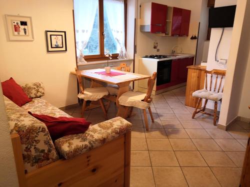 a living room with a table and a kitchen at Appartamenti Pedrini in Comano Terme