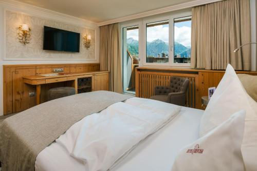 pokój hotelowy z łóżkiem i telewizorem w obiekcie Wellnesshotel Cervosa w mieście Serfaus
