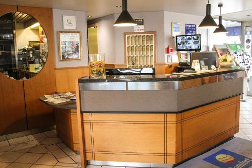 a restaurant with a counter in a store at The Originals City, Hôtel Galaxie, Nice Aéroport in Saint-Laurent-du-Var