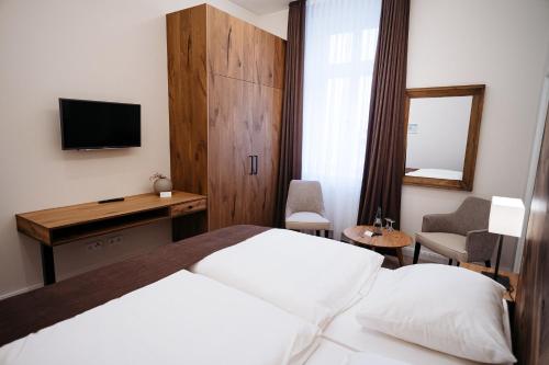 a hotel room with a bed and a desk and a television at Zum Mühlenteich in Bassum