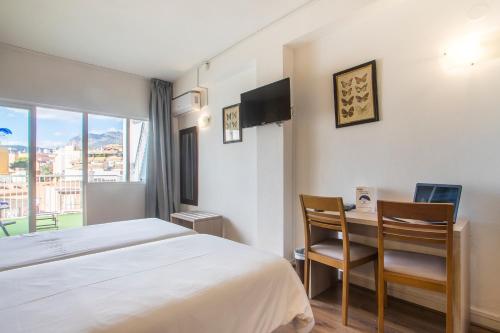 a hotel room with a bed and a desk with a laptop at Hotel Benidorm City Olympia in Benidorm