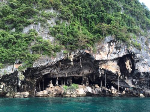 a cave in the side of a mountain in the water at Antonio's Ko Yao Noi in Ko Yao Noi