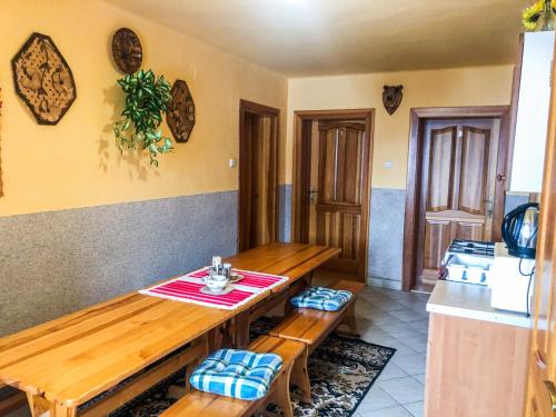 a dining room with a wooden table and benches at Privat u Babky in Ždiar