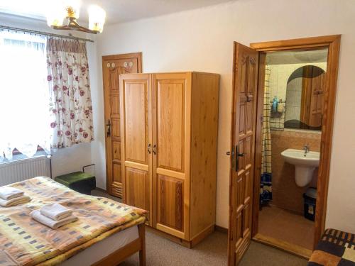 a bedroom with a bed and a bathroom with a sink at Privat u Babky in Ždiar