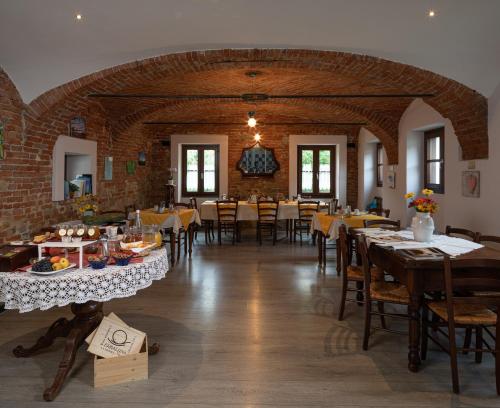 een eetkamer met tafels en stoelen in een gebouw bij Agriturismo Erbaluna in La Morra