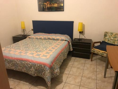 ein Schlafzimmer mit einem Bett und einem Stuhl in der Unterkunft B&B " Guzzi - Inn " in Mandello del Lario