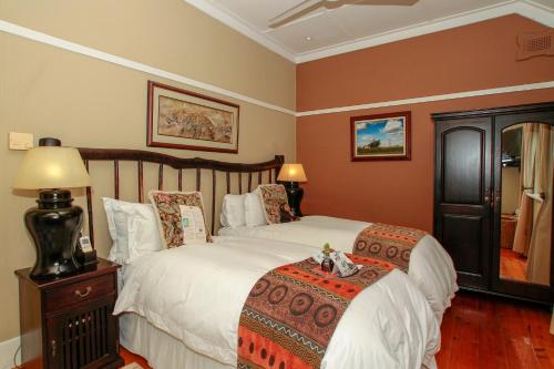 a bedroom with a large bed with white sheets at Acorn B&B in Durban in Durban