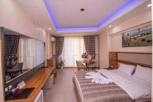 a hotel room with a large bed and a table at Mus Grand Hotel in Muş