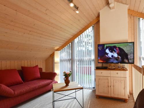 a living room with a red couch and a tv at Ferienhaus Seepferdchen in Baabe