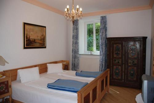 a bedroom with a large white bed with blue pillows at Villa Kreuthhof Appartements in Klosterneuburg