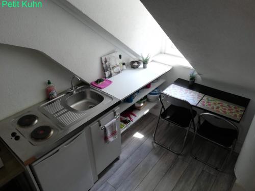 a small kitchen with a sink and a table at Luthin's Home in Strasbourg