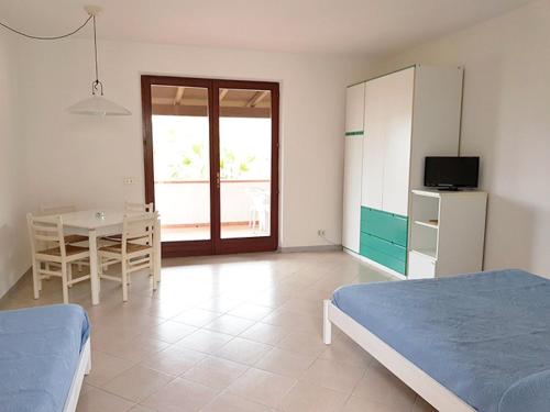Un dormitorio con una cama, una mesa y un frigorífico. en Appartamenti Le Fornaci, en Marina di Campo