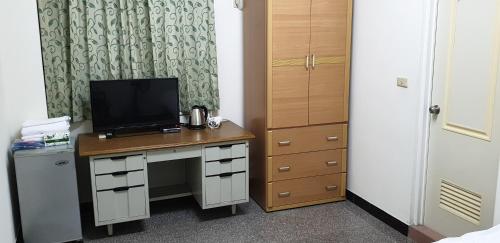 Cette chambre dispose d'un bureau et d'une télévision. dans l'établissement Lanzhou 4th St, à Chiayi
